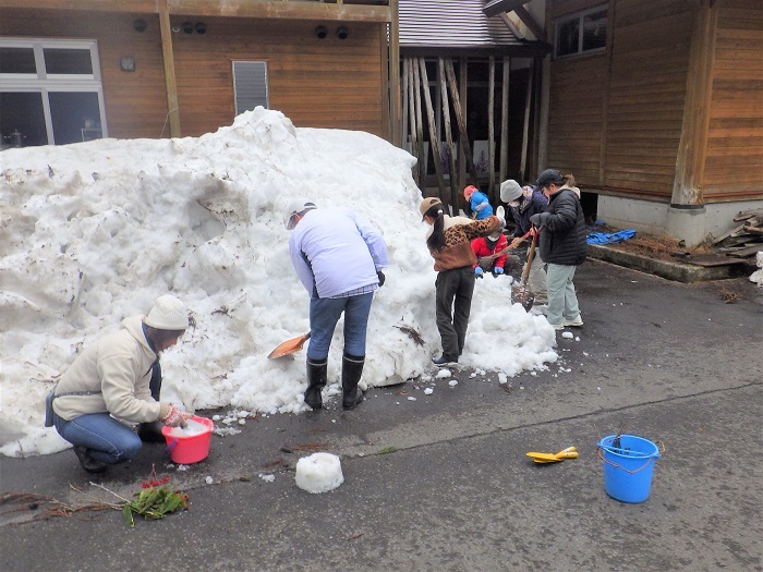 雪を掘る作業の画像