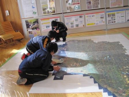 （写真）地図を見ながら附箋を貼っています