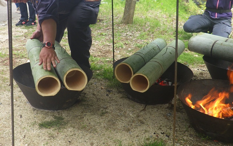 おき火の上に竹筒をセットする画像