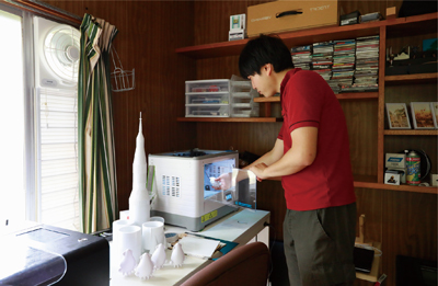 3Dプリンターを操作する小山瑛司さんの写真
