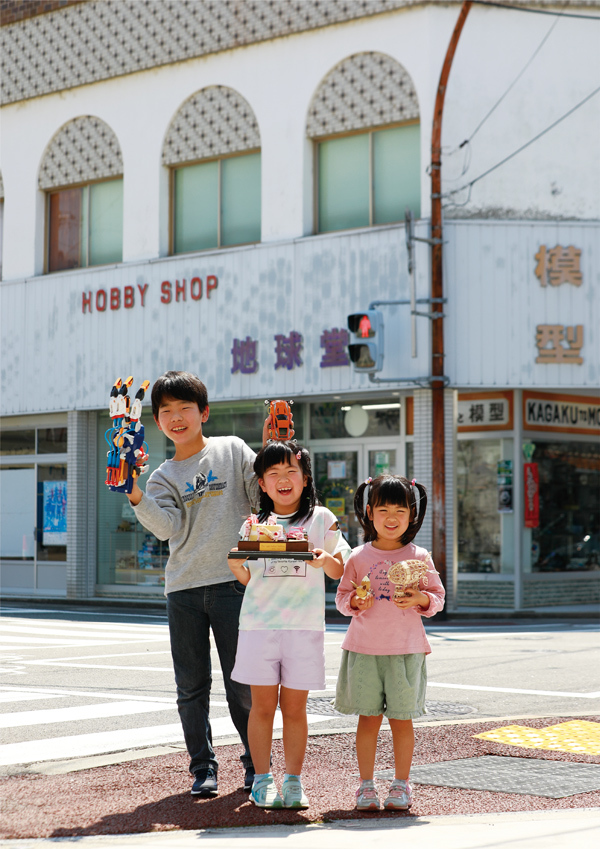 地球堂模型の前で模型を持つ子供の写真