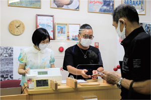 お客さんを迎え入れる和田浩章さんと更沙さんの写真