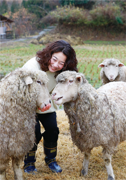 羊の世話をする笠木真衣さんの写真