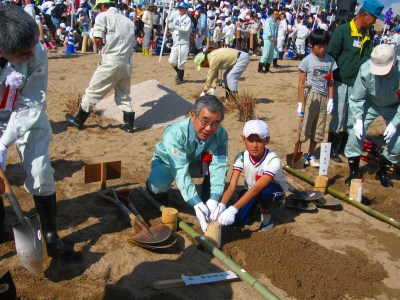 小学生とヨシを植栽する知事