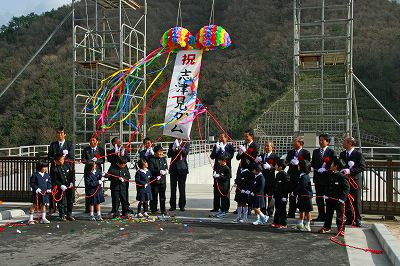 工事関係者らとくす玉を割って完成を祝う知事の写真