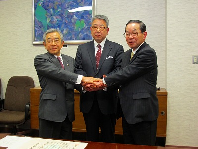 傍島社長、田中江津市長と握手する知事