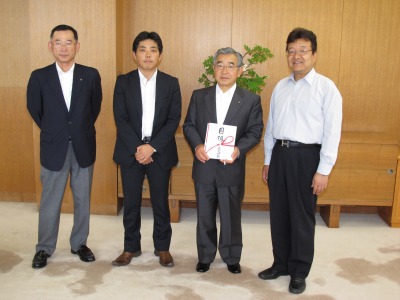 訪問者の皆さんと一緒に記念撮影をする知事