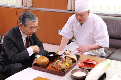 料理の説明を受ける知事