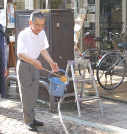 打ち水をする知事