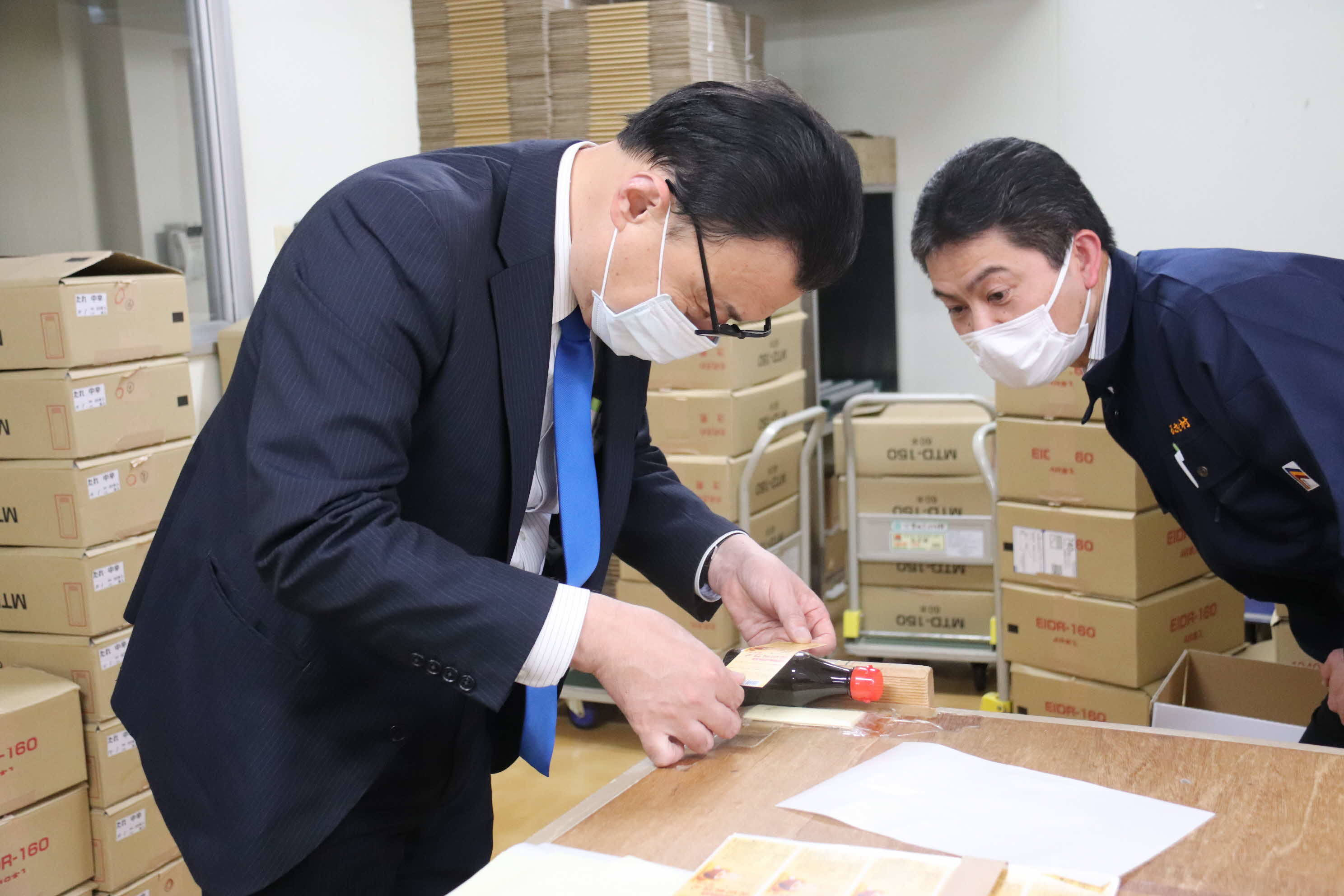 農産加工品出荷現場で商品のラベル貼りを体験する知事