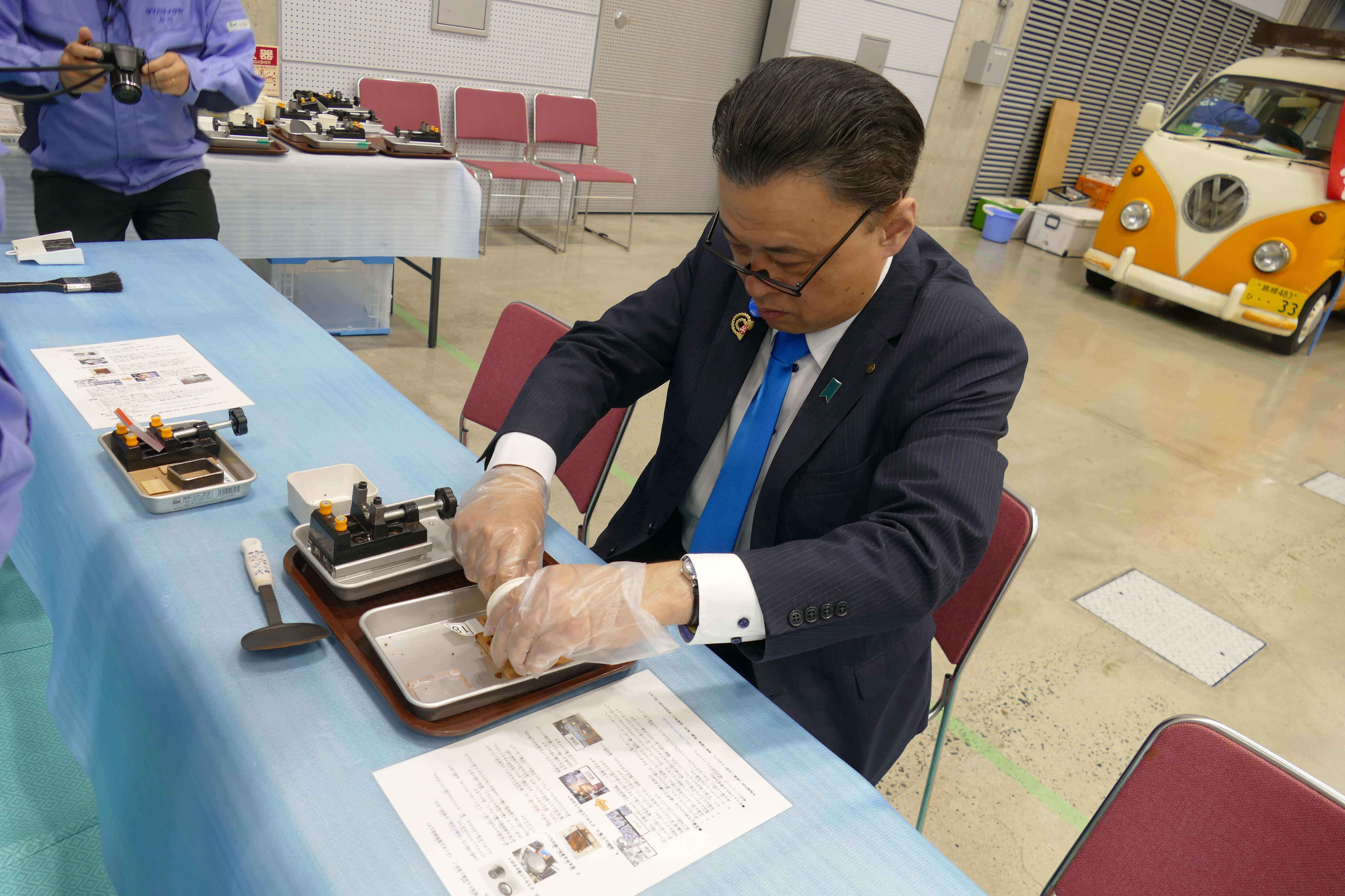 金属を溶かしたキーホルダー作りを体験する知事