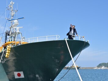 浜吉丸船上から会場の皆さんへ手を振る知事