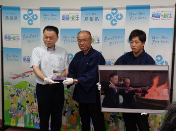 堀尾村下（中央）から贈呈を受ける知事