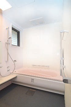 浴槽の周囲に手すりを付け、天井に温風ヒーターを設置した風呂場＝久家邸の写真