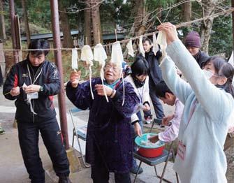 住民の手ほどきでイカの一夜干しを体験する企画の写真