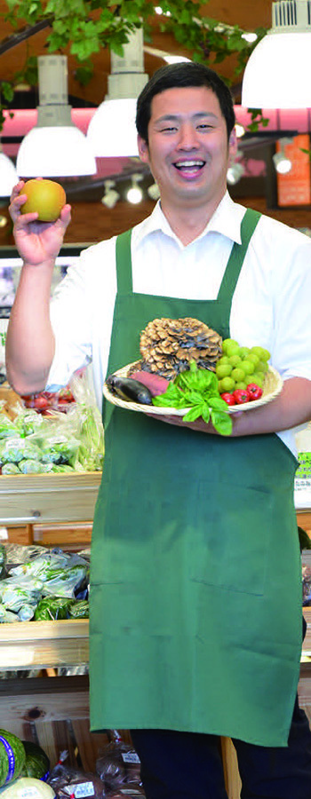 野菜や果物を持った店員の写真