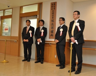 松江市・島根県共同設置保健所の除幕式の様子。両自治体の代表者が松江保健所の看板の前で撮影