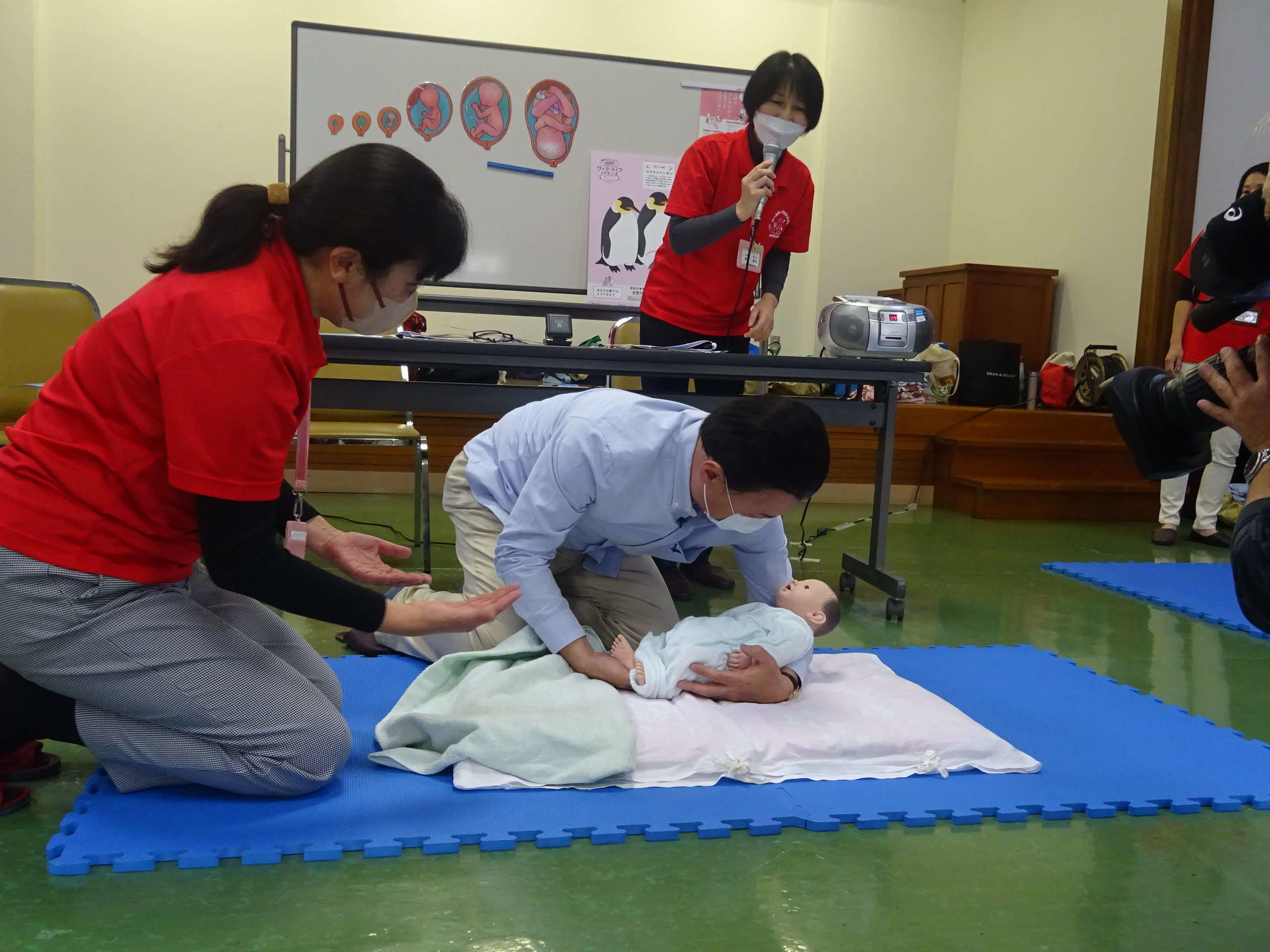 赤ちゃん人形を抱っこする知事