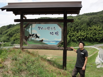 ダムの見える牧場（大石氏＆看板）