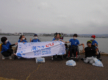 宍道湖を背に横断幕を広げて並んでいる様子