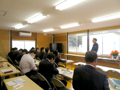 担当者の話を椅子に座って聞く生徒