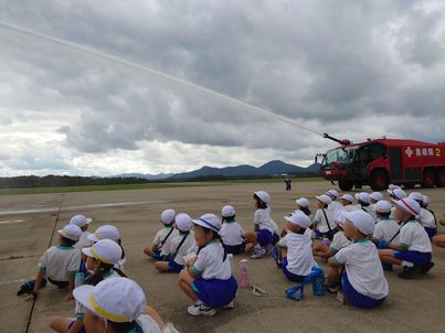 化学消防車のメインタレットからの放水を見学する周布小学校の写真