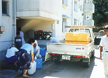 写真（４）：平成６年隠岐郡隠岐の島町での給水車からポリタンクで水くみする住民のようす