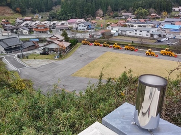 雨量局の上から見た弥栄の町並みと冬に備えて並んだ除雪車の写真です。