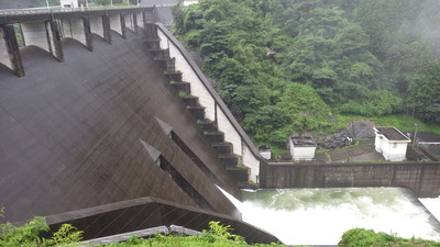 右岸側から見た常用洪水吐きから水を流している御部ダムの写真です。