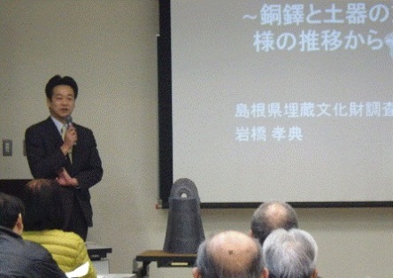 銅鐸や土器の文様の解説をする岩橋係長