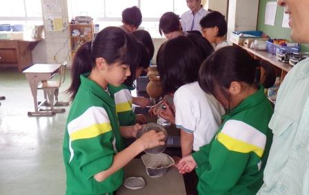 学校周辺の遺跡の出土品を見学する児童