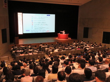 講演会の写真原さんがスクリーンに映された資料を説明