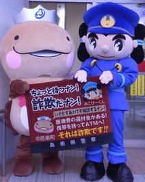 みこぴーくんとオオナン・ショウが株式会社ダスキン作成の還付金等詐欺被害防止マットを持つ