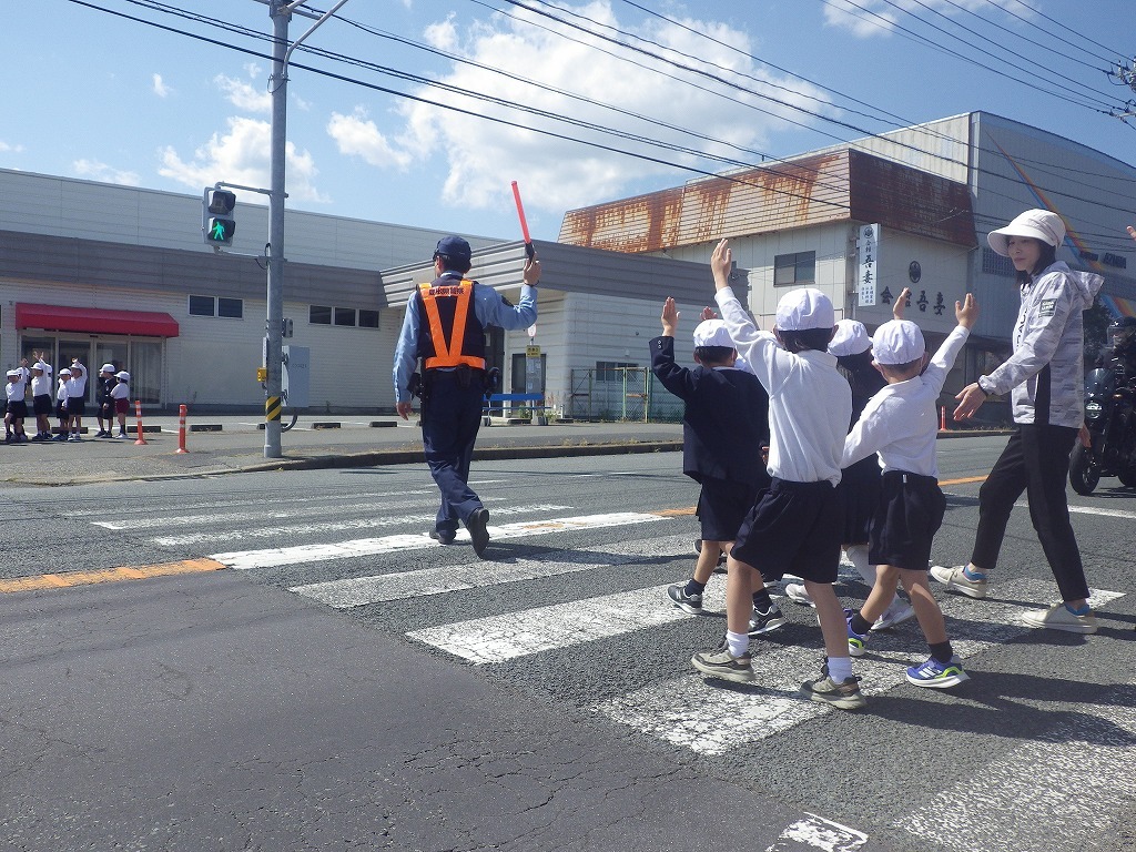 警察官と横断歩道を渡る児童
