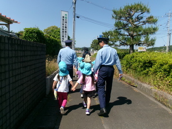 警察官から交通ルールを学びながら帰る園児の写真