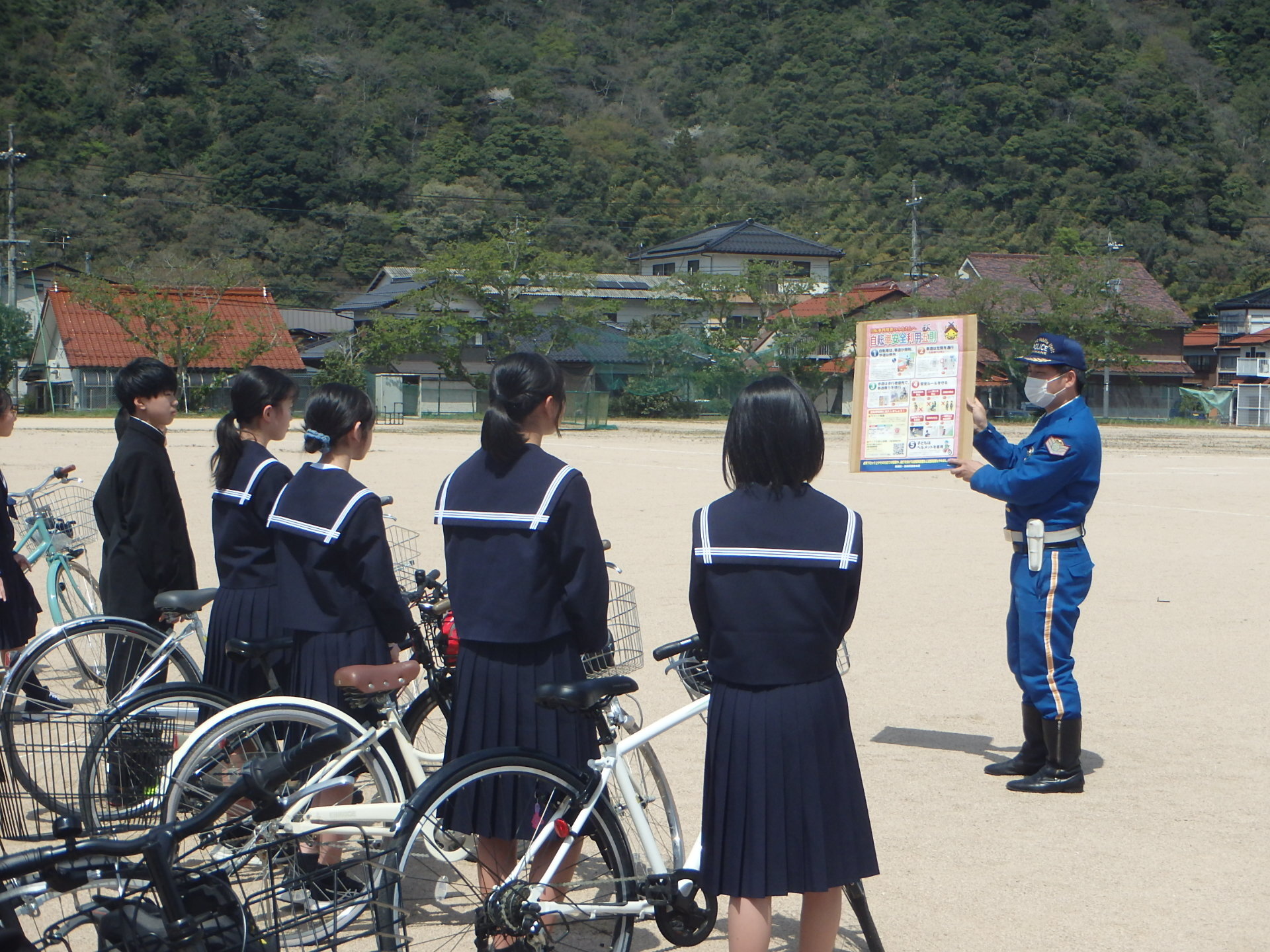 津和野警察署の警察官が中学生に自転車の点検方法を指導しています。